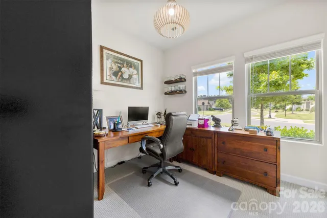 a view of a workspace with furniture and a window