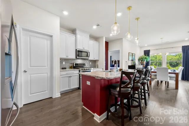 a kitchen with kitchen island granite countertop wooden floors and stainless steel appliances