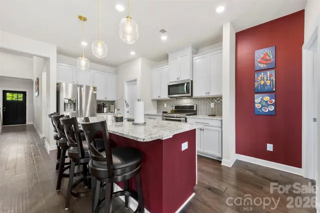 a kitchen with kitchen island granite countertop a sink counter top space appliances and cabinets