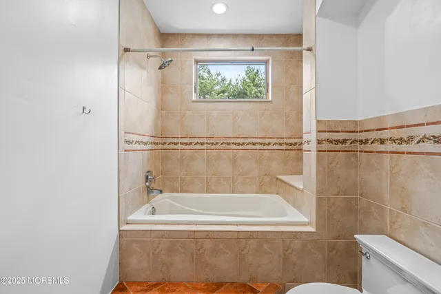 a bathroom with a granite countertop sink a toilet and a mirror