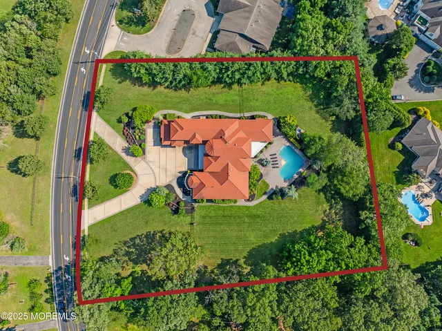 an aerial view of residential houses with outdoor space and trees