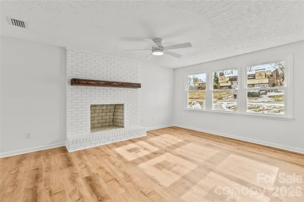 a view of an empty room with a window and closet