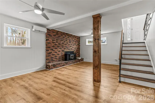a view of empty room with stairs and wooden floor