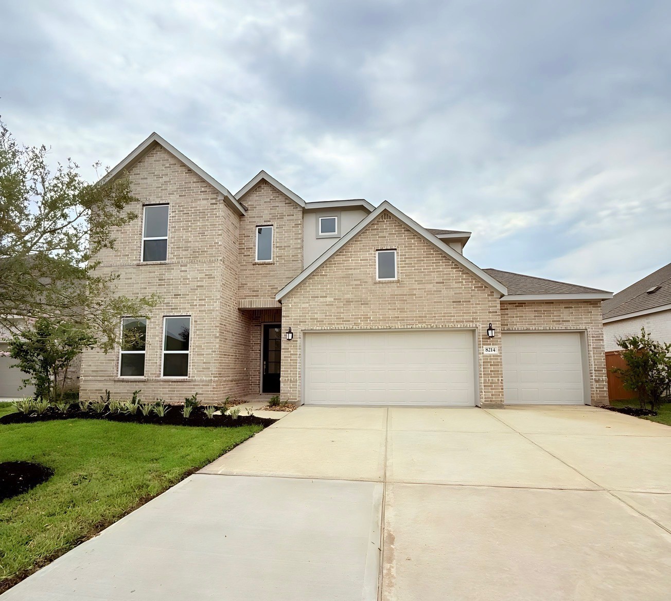 a front view of a house with a yard and trees