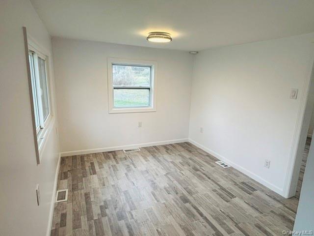 280 Hall Hill Road Ancram, NY 12502 - Photo 12 of 19 an empty room with wooden floor and windows