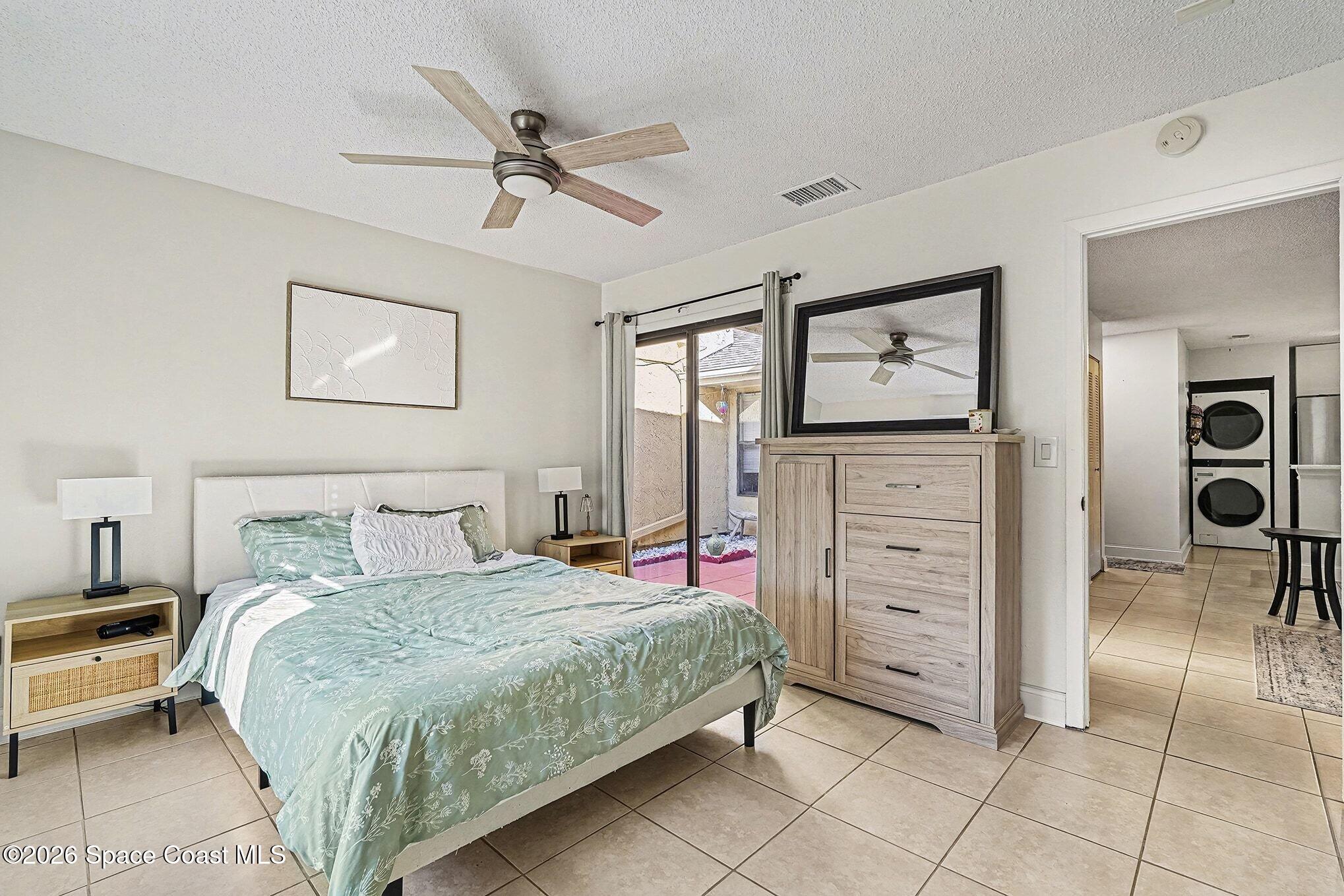 1491 Sheafe Avenue Northeast, Unit 104 Palm Bay, FL 32905 - Photo 8 of 19 a bedroom with a bed and a chandelier