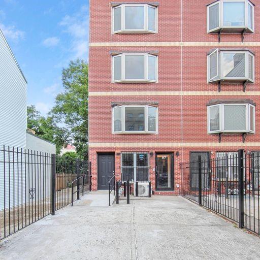 a front view of a brick building with a bench