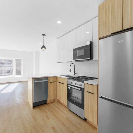 87 Adelphi Street Brooklyn, NY 11205 - Photo 18 of 35 a kitchen with granite countertop a stove top oven sink and cabinets