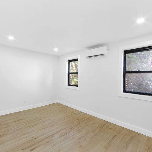 87 Adelphi Street Brooklyn, NY 11205 - Photo 22 of 35 an empty room with wooden floor and window