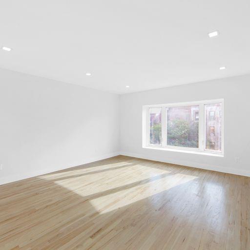 87 Adelphi Street Brooklyn, NY 11205 - Photo 30 of 35 a view of an empty room with wooden floor and a window