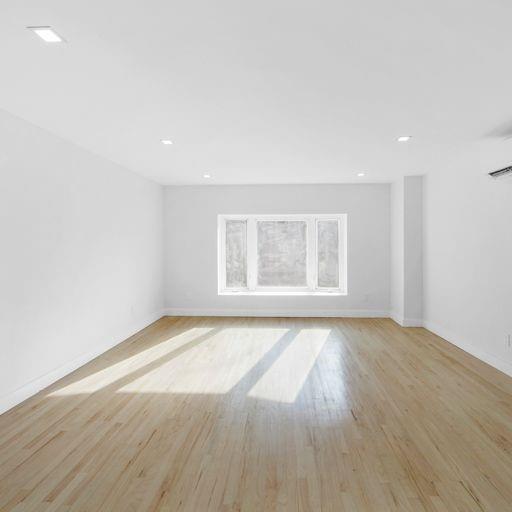 87 Adelphi Street Brooklyn, NY 11205 - Photo 32 of 35 an empty room with wooden floor and windows