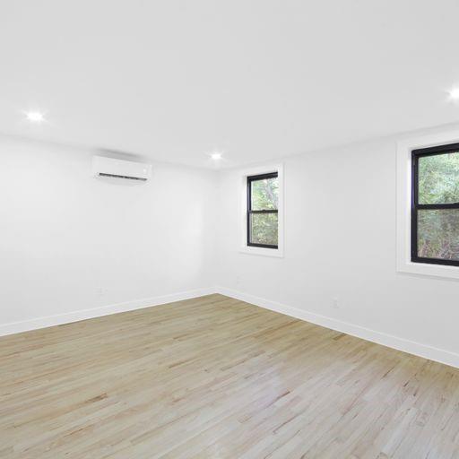 87 Adelphi Street Brooklyn, NY 11205 - Photo 34 of 35 an empty room with wooden floor and windows