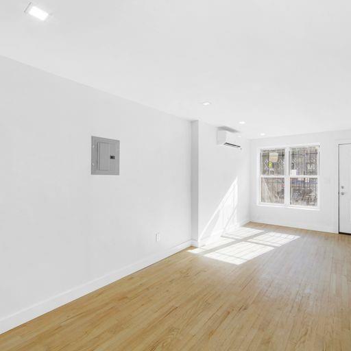 87 Adelphi Street Brooklyn, NY 11205 - Photo 4 of 35 an empty room with wooden floor and windows