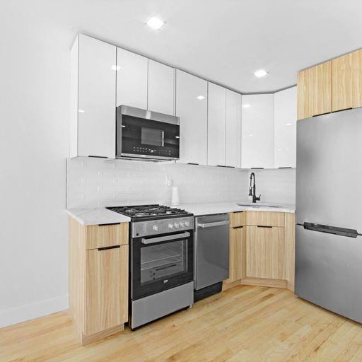 87 Adelphi Street Brooklyn, NY 11205 - Photo 10 of 35 a kitchen with cabinets stainless steel appliances and wooden floor