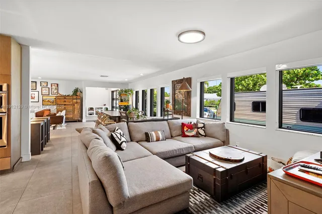 a kitchen with stainless steel appliances kitchen island granite countertop a refrigerator a sink a stove a dining table and chairs