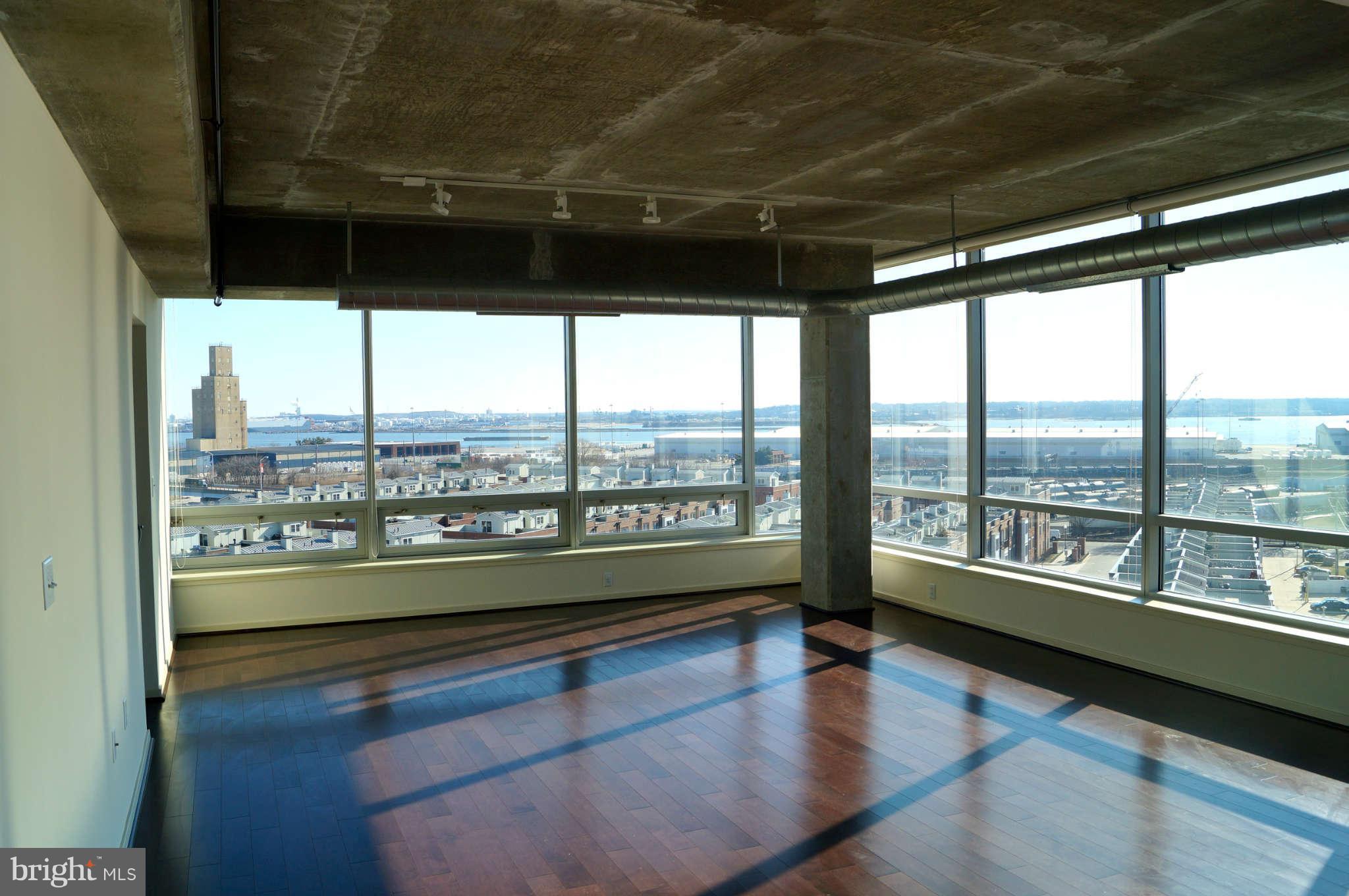 1200 Steuart Street, Unit 822 Baltimore, MD 21230 - Photo 1 of 30 a living room with hardwood floor and a large window