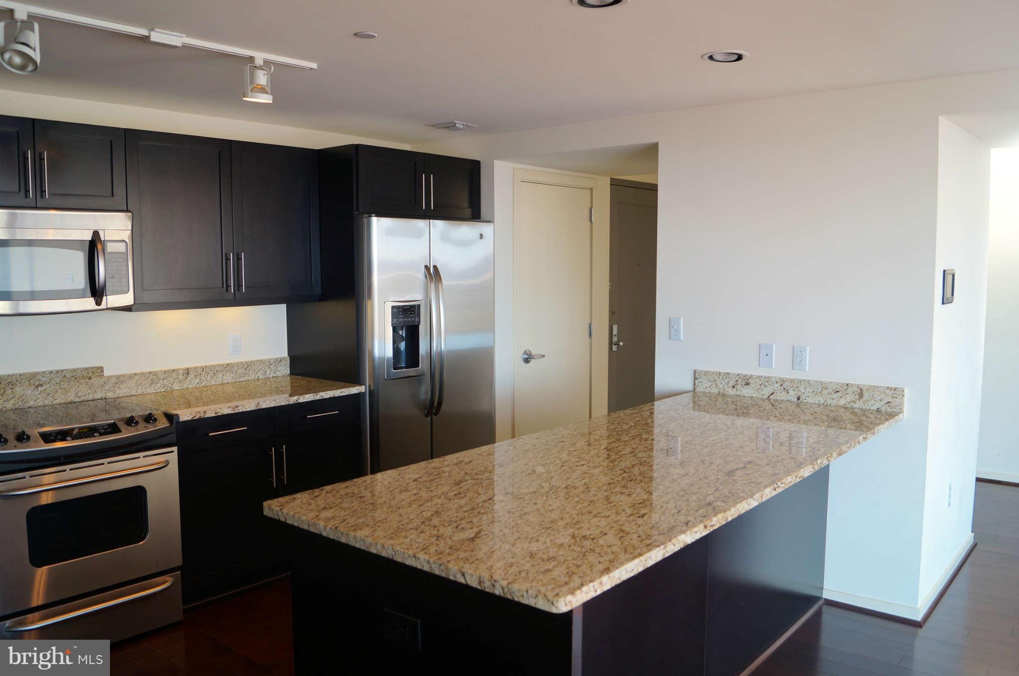 1200 Steuart Street, Unit 822 Baltimore, MD 21230 - Photo 12 of 30 a kitchen with stainless steel appliances granite countertop a sink stove and refrigerator