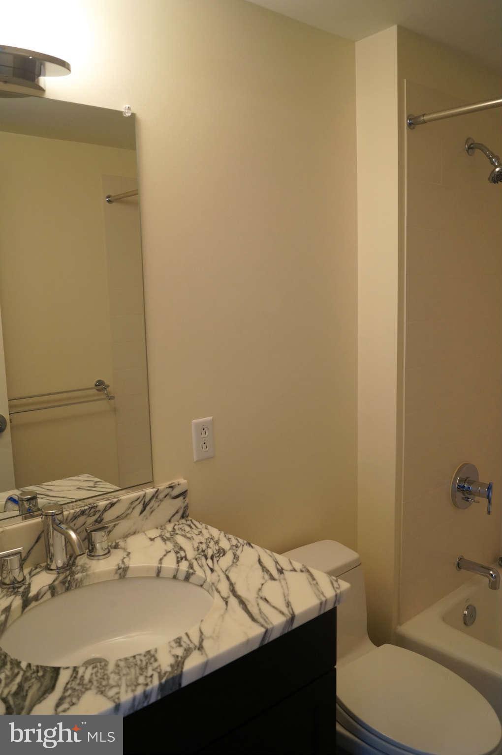 1200 Steuart Street, Unit 822 Baltimore, MD 21230 - Photo 16 of 30 a bathroom with a granite countertop sink and a mirror