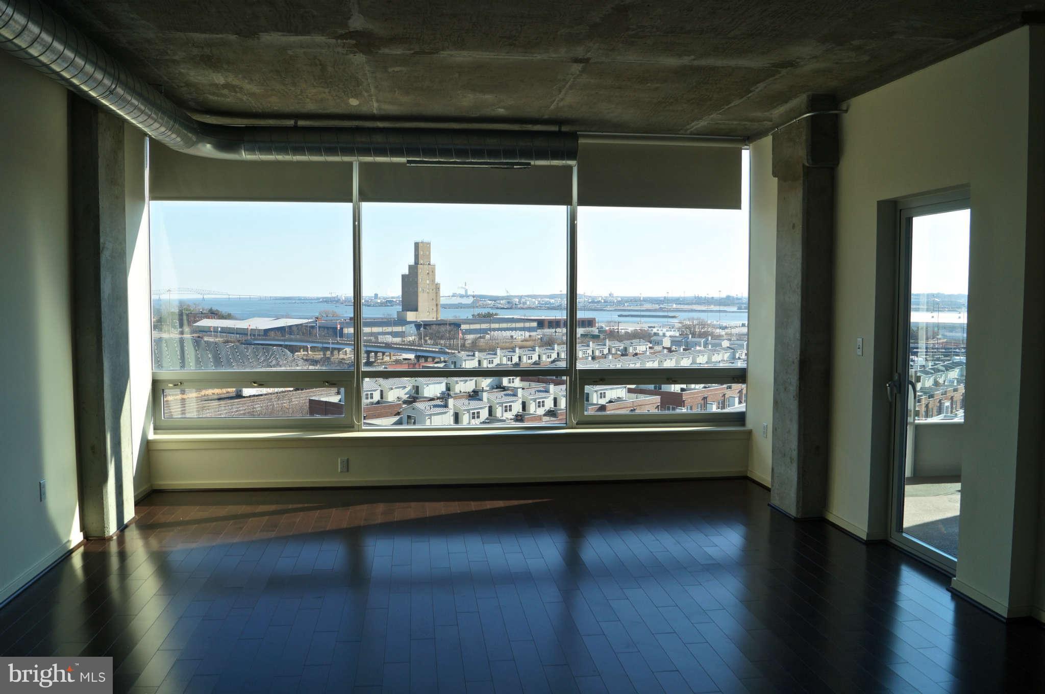 1200 Steuart Street, Unit 822 Baltimore, MD 21230 - Photo 7 of 30 a view of a room with wooden floor and windows