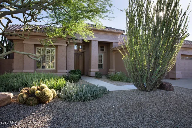 a view of a house with a yard and potted plants