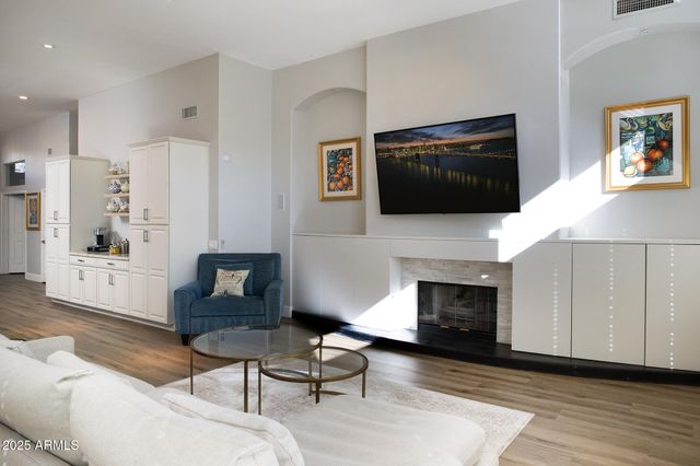 a living room with furniture a flat screen tv and a fireplace