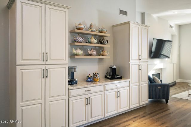 a kitchen with stainless steel appliances white cabinets and wooden floor