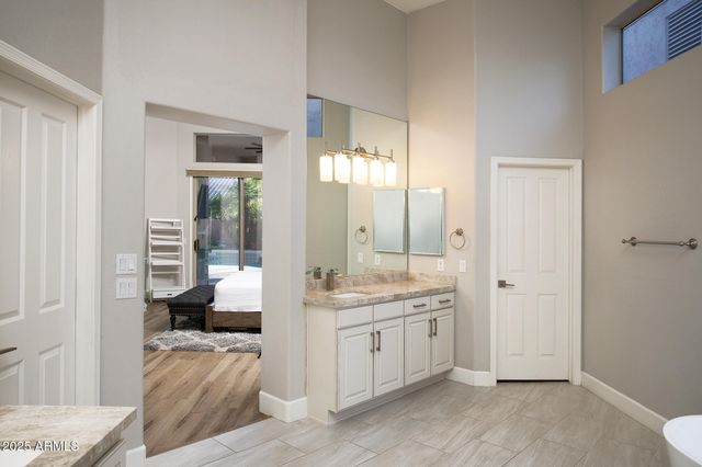 a spacious bathroom with a granite countertop sink and a mirror