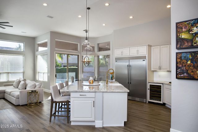 a kitchen with stainless steel appliances kitchen island granite countertop a refrigerator a sink and a stove