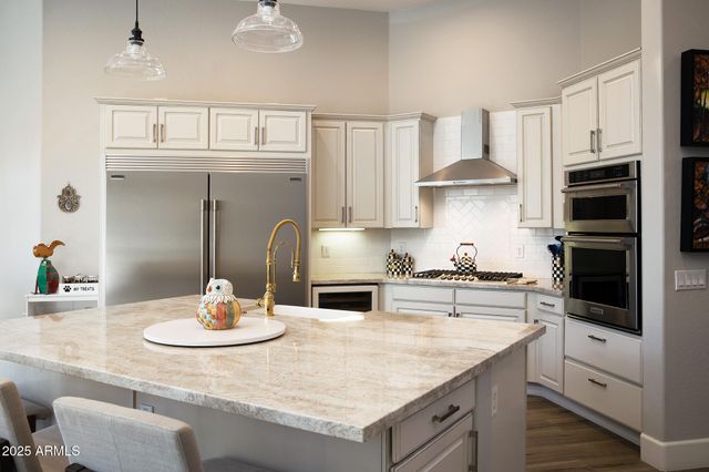 a kitchen with kitchen island a sink a stove and cabinets