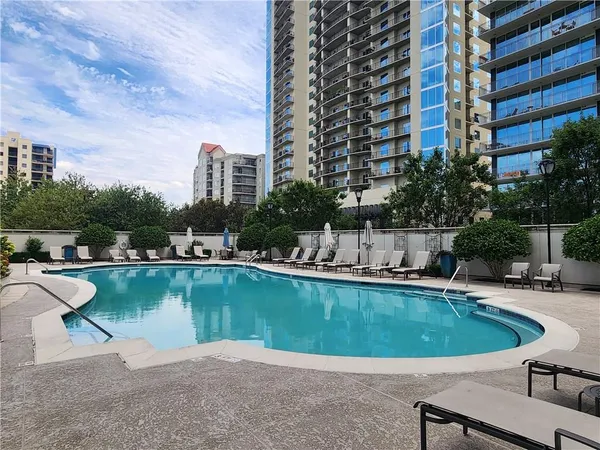 a view of a swimming pool with a yard and plants