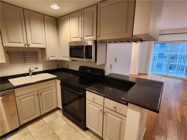 a kitchen with white cabinets and refrigerator