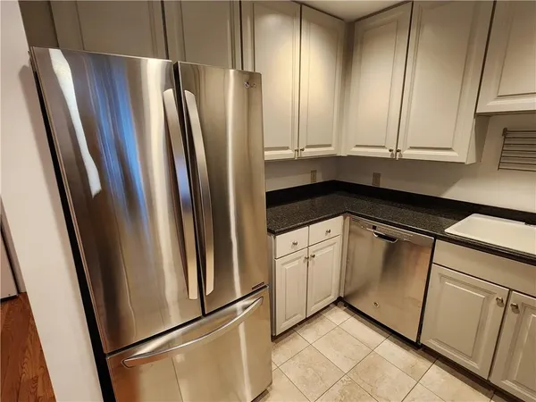 a view of a kitchen with stainless steel appliances granite countertop a sink refrigerator and microwave