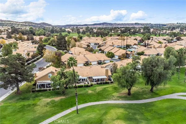 an aerial view of residential houses with outdoor space and trees