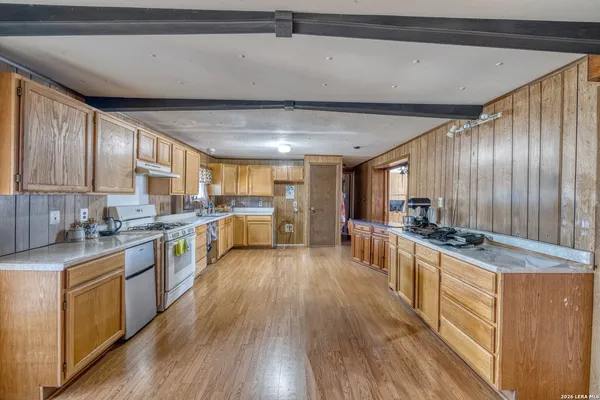 a kitchen with stainless steel appliances granite countertop lots of counter top space and wooden floors