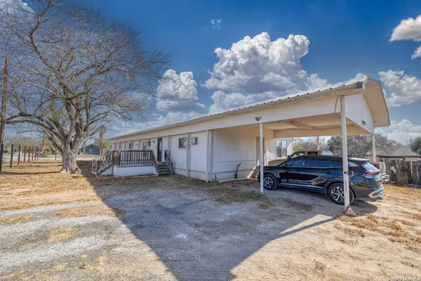 a view of a house with a yard and wooden fence