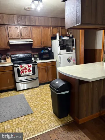 a kitchen with stainless steel appliances a stove a sink and a refrigerator