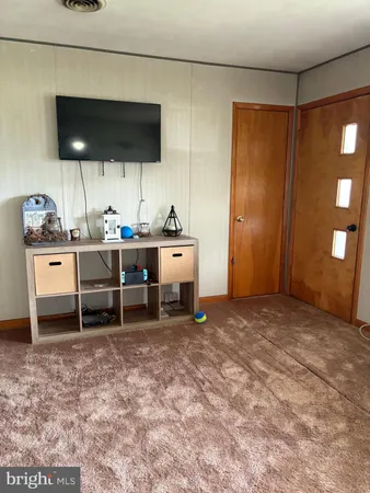 a view of a workspace with furniture and a flat screen tv