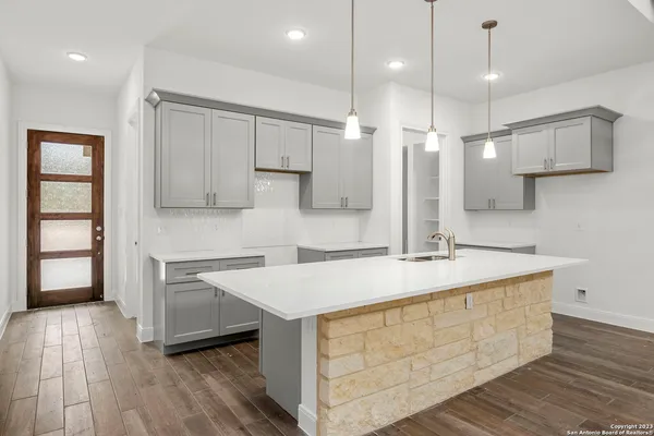 a kitchen with kitchen island a sink stainless steel appliances and cabinets