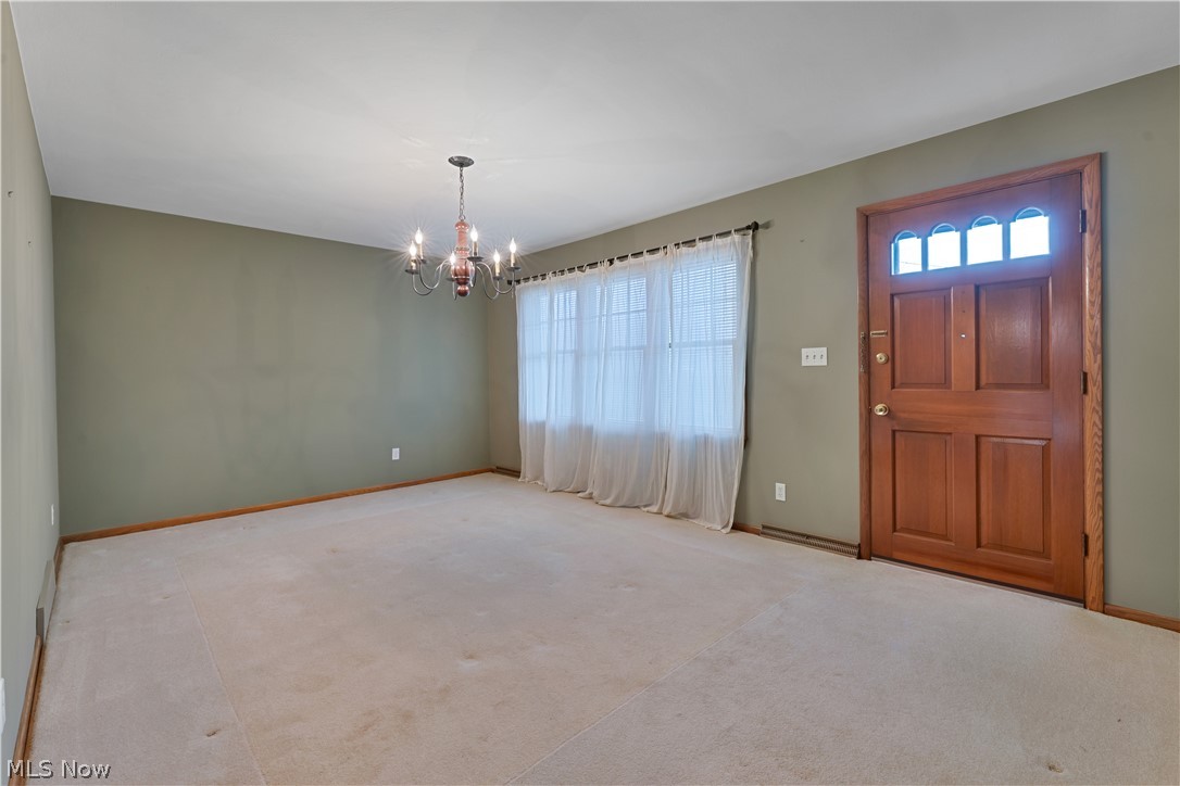 6599 Struthers Road Youngstown, OH 44514 - Photo 6 of 29 Foyer entrance featuring healthy amount of natural light, carpet, and a chandelier