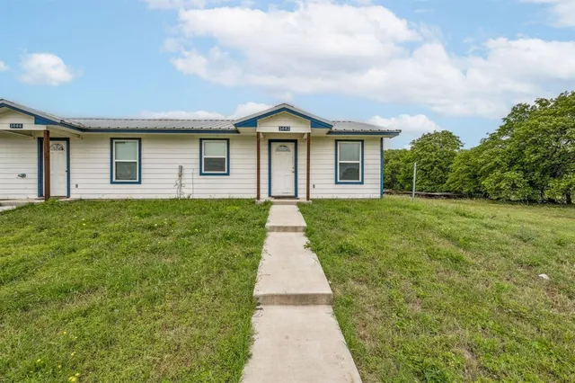 a backyard of a house with lots of green space and lake view