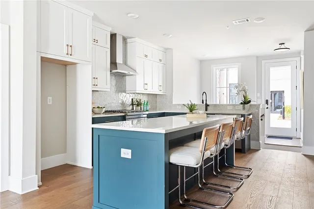 a kitchen with stainless steel appliances granite countertop a table chairs refrigerator and sink