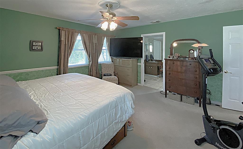 626 Orchid Lane Altamonte Springs, FL 32714 - Photo 11 of 24 a bedroom with a bed a television and dresser