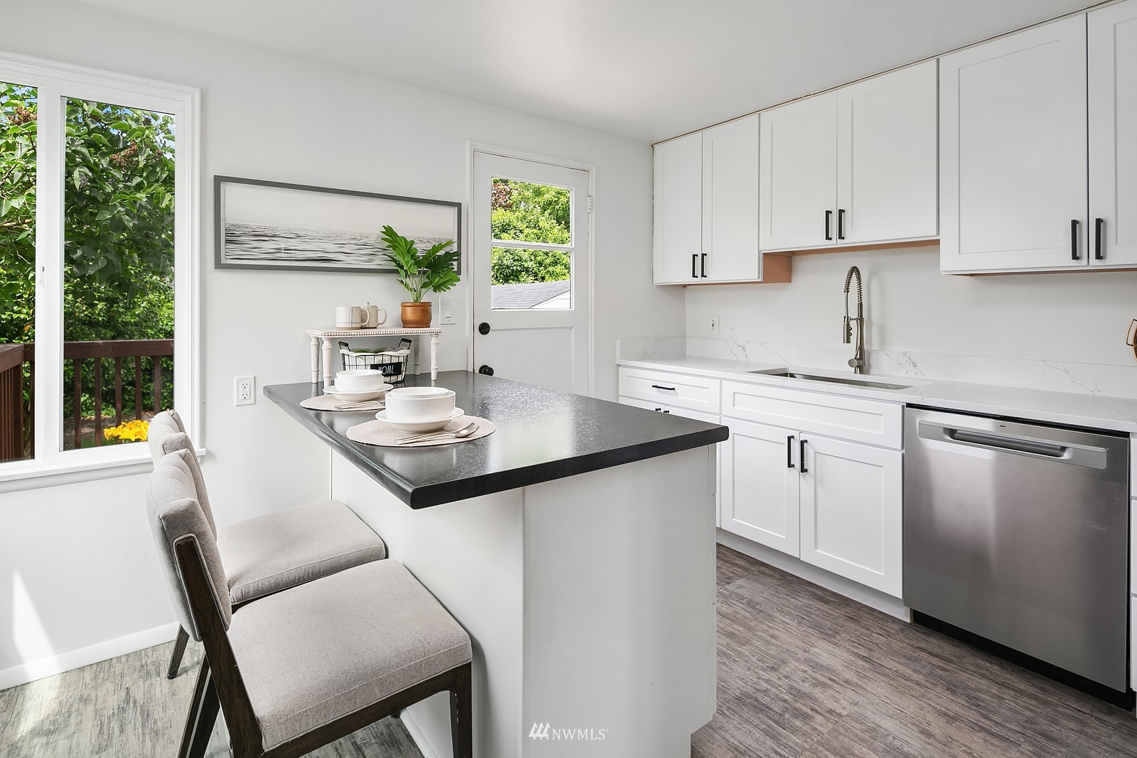336 Northwest 47th Street Seattle, WA 98107 - Photo 8 of 36 a kitchen with a sink stove and white cabinets with wooden floor