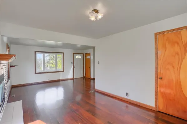 an empty room with window and wooden floor