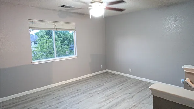 a view of a room with a window and wooden floor