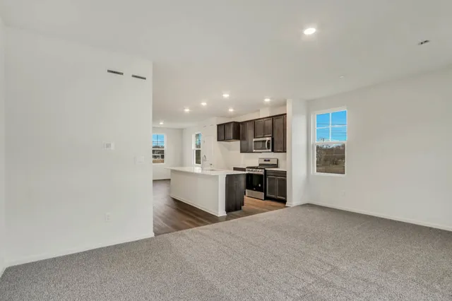 a view of kitchen with stainless steel appliances kitchen island a sink dishwasher a stove and a refrigerator with wooden floor