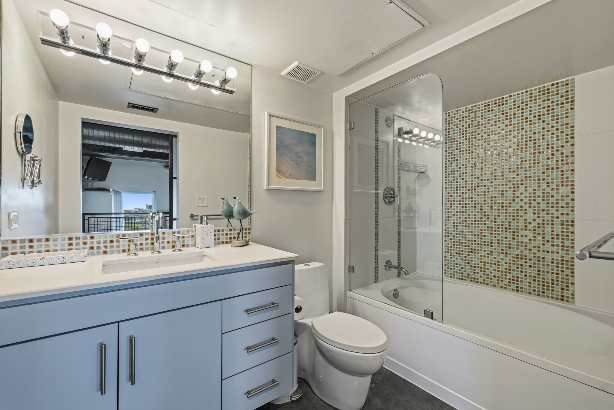 2000 Bagby Street, Unit 11415 Houston, TX 77002 - Photo 17 of 35 Beautifully remodeled primary bath with contemporary vanity, sleek fixtures, modern cabinetry, and a glass enclosed spa-inspired tub & shower accented with stunning mosaic tile.