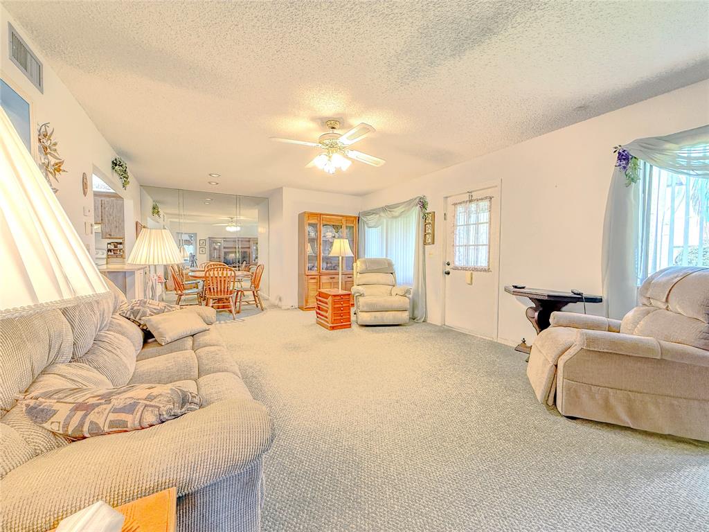 329 Knotty Pine Circle, Unit C2 Greenacres, FL 33463 - Photo 15 of 39 a living room with furniture and a large window