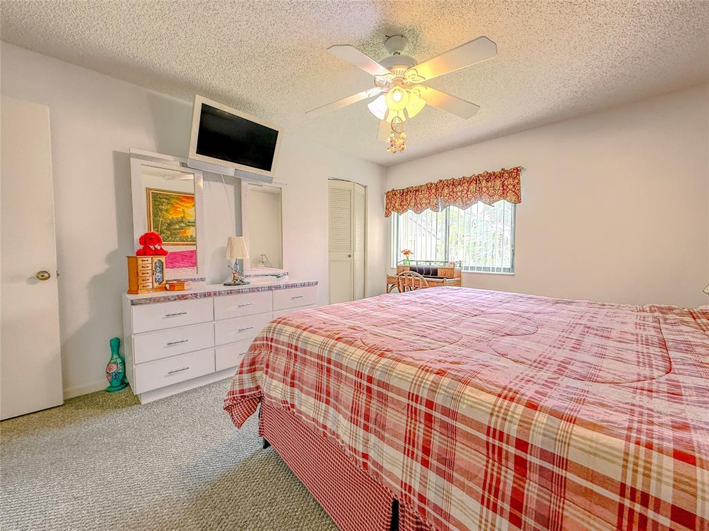 329 Knotty Pine Circle, Unit C2 Greenacres, FL 33463 - Photo 20 of 39 a bedroom with a bed and a flat screen tv