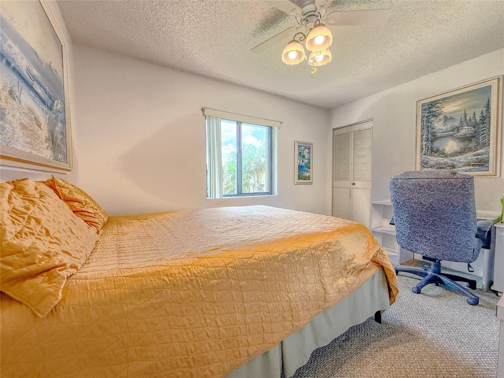 329 Knotty Pine Circle, Unit C2 Greenacres, FL 33463 - Photo 9 of 39 a bedroom with a bed and dresser with chair